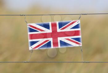 Border fence - Old plastic sign with a flag - United Kingdom