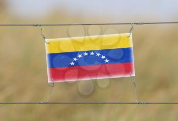 Border fence - Old plastic sign with a flag - Venezuela