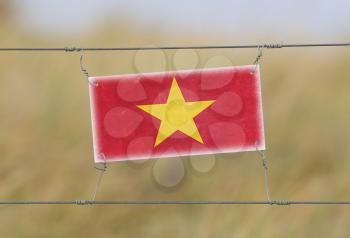 Border fence - Old plastic sign with a flag - Vietnam