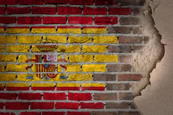 Dark brick wall texture with plaster - flag painted on wall - Spain