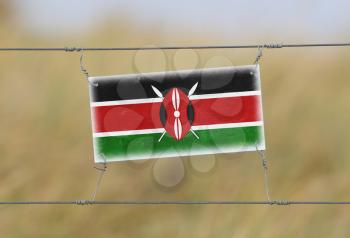 Border fence - Old plastic sign with a flag - Kenya