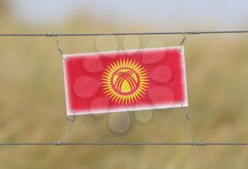Border fence - Old plastic sign with a flag - Kyrgyzstan