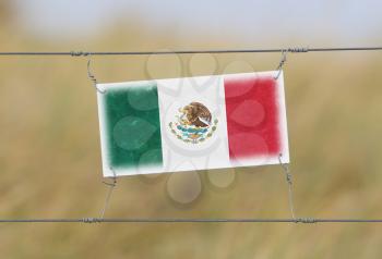 Border fence - Old plastic sign with a flag - Mexico