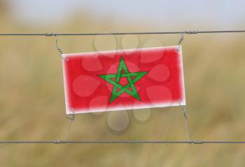Border fence - Old plastic sign with a flag - Morocco