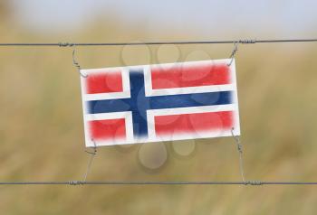 Border fence - Old plastic sign with a flag - Norway