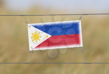 Border fence - Old plastic sign with a flag - Philippines