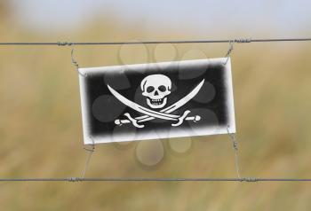 Border fence - Old plastic sign with a flag - Pirate