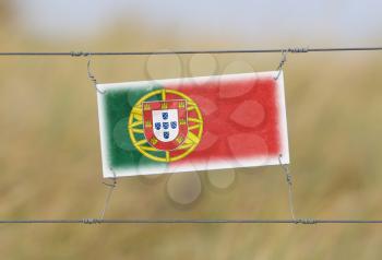 Border fence - Old plastic sign with a flag - Portugal