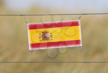 Border fence - Old plastic sign with a flag - Spain