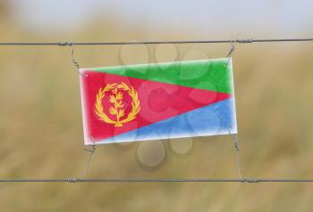 Border fence - Old plastic sign with a flag - Eritrea