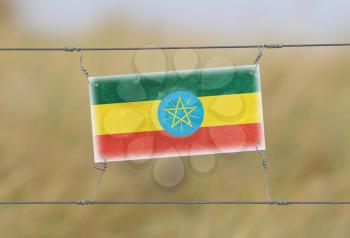 Border fence - Old plastic sign with a flag - Ethiopia