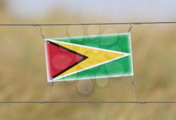 Border fence - Old plastic sign with a flag - Guyana