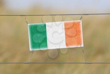 Border fence - Old plastic sign with a flag - Ireland