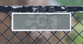 Sign hanging on an old metallic gate - Good morning