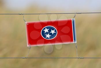 Border fence - Old plastic sign with a flag - Tennessee