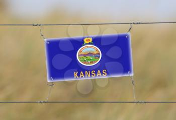 Border fence - Old plastic sign with a flag - Kansas