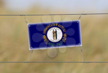 Border fence - Old plastic sign with a flag - Kentucky