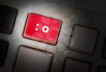 Red button on a dirty old panel, selective focus - smiley