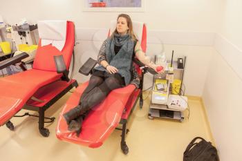 Donor in an armchair donates blood at hemotransfusion station