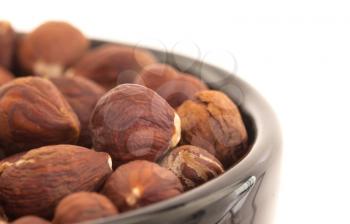 Hazelnuts in a bowl, isolated on white