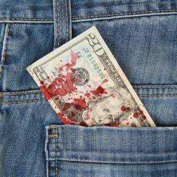 Macro shot of trendy jeans with american 20 dollar bill on its pocket, blood