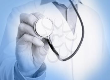 Close up of a Doctor's hand, holding a stethoscope outstretched towards the viewer, medical blue