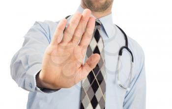 Male doctor holding up his hand in a Halt or Stop gesture as he signals he has had enough, or denies access or tells someone to go away, isolated on white