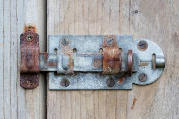 Close up of rusty slide locked wooden door