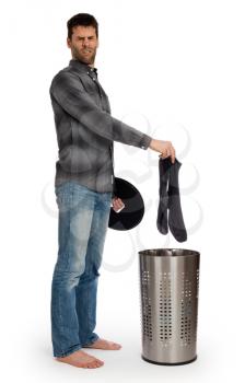 Young man putting dirty socks in a laundry basket, isolated on white