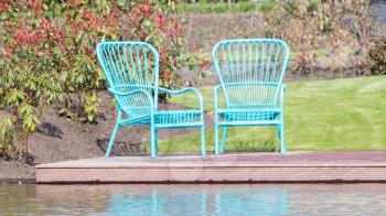 Two blue chairs at the waterfront, dutch garden