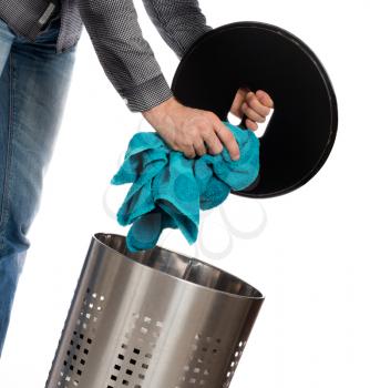 Young man putting a dirty towel in a laundry basket, isolated