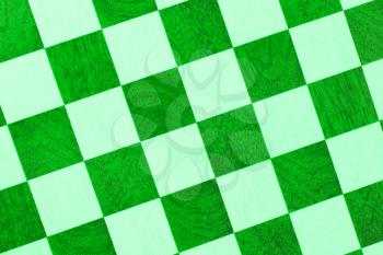 Very old wooden chess board, isolated close-up, green