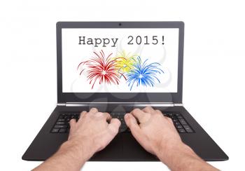 Man working on laptop, happy 2015, isolated