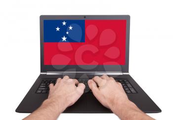 Hands working on laptop showing on the screen the flag of Samoa