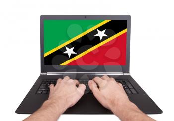 Hands working on laptop showing on the screen the flag of Vanuatu
