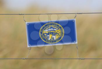 Border fence - Old plastic sign with a flag - Nebraska