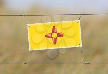 Border fence - Old plastic sign with a flag - New Mexico