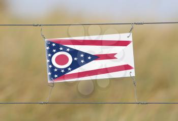 Border fence - Old plastic sign with a flag - Ohio