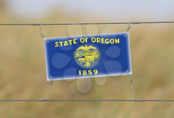 Border fence - Old plastic sign with a flag - Oregon