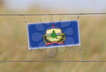 Border fence - Old plastic sign with a flag - Vermont