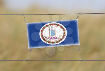 Border fence - Old plastic sign with a flag - Virginia