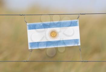 Border fence - Old plastic sign with a flag - Argentina