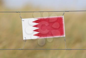 Border fence - Old plastic sign with a flag - Bahrain