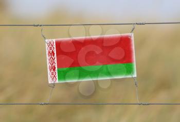 Border fence - Old plastic sign with a flag - Belarus