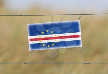 Border fence - Old plastic sign with a flag - Cape Verde