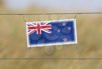 Border fence - Old plastic sign with a flag - New Zealand