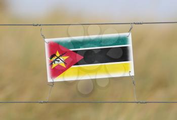 Border fence - Old plastic sign with a flag - Mozambique