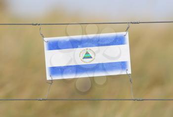 Border fence - Old plastic sign with a flag - Nicaragua