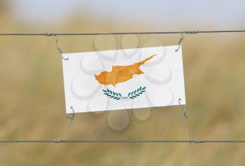 Border fence - Old plastic sign with a flag - Cyprus