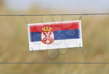 Border fence - Old plastic sign with a flag - Serbia